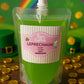Green cocktail pouch labeled 'Leprechaun' with a rainbow and gold coins in the background